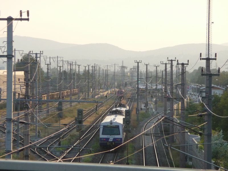 Die Sonne ber Wien geht um 19:10 Uhr langsam unter. Gerade fahren der Triebwagen 6020 305-6 und die TAURUS-Lok 1116 175-9 in den Bahnhof von Leopoldau.