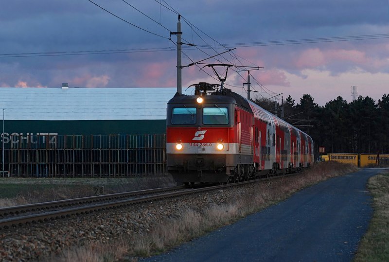 Die Sonne war bereits untergegangen, als diese Aufnahme entstand: 1144 286 war am 24.03.2009 mit R 2252  Region 10 vor Wien  unterwegs von Wien Westbahnhof nach Retz. Das Foto entstand kurz nach Stockerau.