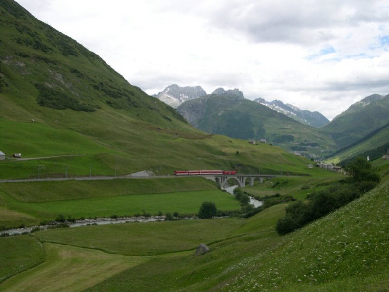 Die Stelle etwas weiter unten ist bekannt von zahlreichen Kalenderfotos. Ein Regionalzug im Tal der Furkareuss bei Hospental am 06.07.2005, aufgenommen von der Furkapassstrae.