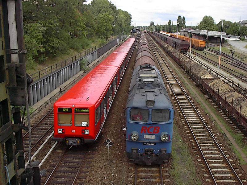 DIe V200 023 der Prignitzer Eisenbahn am 24.08.2001 im Gterbahnhof Berlin-Neuklln; daneben die S45 nach Flughafen Schnefeld. Im Hintergrund der S-Bahnhof Neuklln.