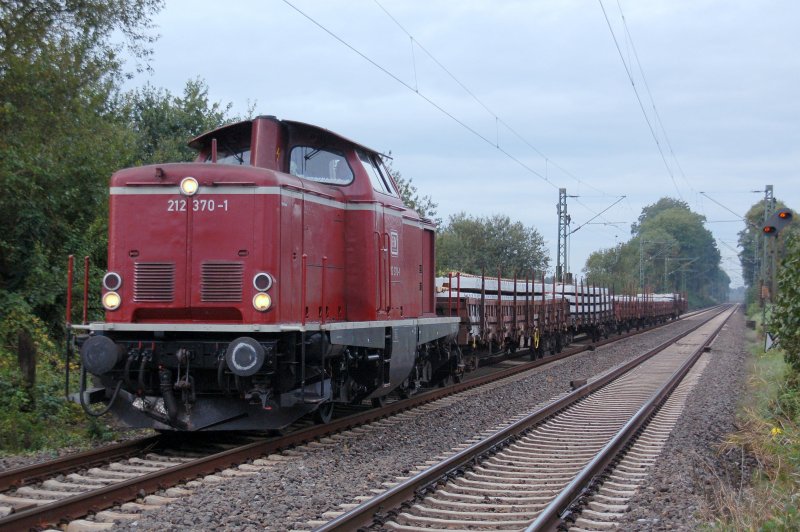 Diesellok 212 370-1 (V 100 ) der EfW-Verkehrsgesellschaft mbH  mit Flachwagen, beladen mit neuen Betonschwellen, in Castrop-Rauxel am Bahnbergang Becklem am 28.09.2007.