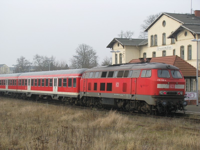 Diesellok BR 218 158-4 mit RE 21616 steht am Gleis 3 des Bahnhofes Grevesmhlen, Im Hintergrund ist das verlassene Empfangsgebude zu sehen. 05.02.2009