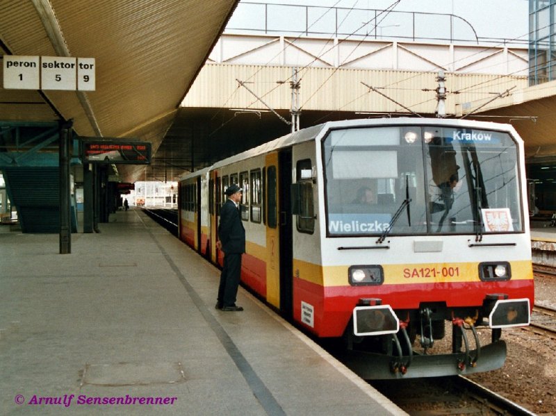 Dieseltriebzug SA121-001+SA101-001 wird gleich von Krakow nach Wieliczka fahren.
Die Dieseltriebzge der Reihe SA101+SA121 bestehen aus gleichartigen Trieb- (SA101) und Steuerwagen (SA121). Auch auf polnischen Schienen sind sie eine Raritt: Es wurden zwischen 1990-92 nur 3 dieser Triebzge (Achsfolge 1'A + 1'1')  von ZNTK Poznań gebaut.
15.04.2004 Krakow Glowny