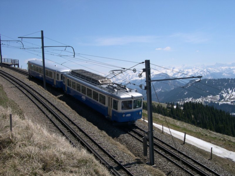 Dieser Zug der ARB benutzt sein Stammgleis auf den Gipfel. Erst seit einigen Jahren, seit der Fussion beider Bahnen, existiert eine Weiche zwischen beiden Schienenstrngen. Vorher fuhren die Bergbahnen strikt getrennt auf den Gipfel. Wir befinden uns am 03.05.2006 auf dem Wanderweg zwsichen Kulm und Staffel.