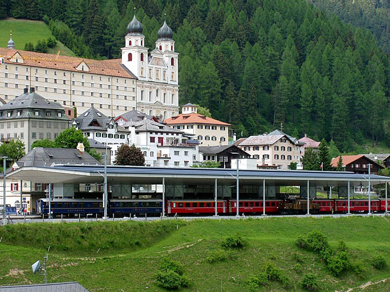 Disentis GR. Bahnhof mit RhB-Zug (u.a. Pullmann-Wagen). RhB-Krokodil Ge 6/6 I rechts unten. Benediktinerkloster oben links, Aufnahme vom 30. Mai 2003