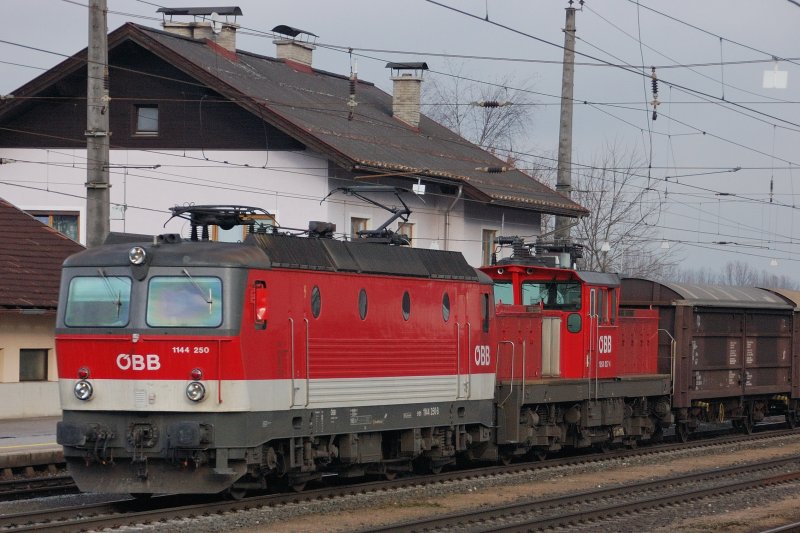 Doppeltes Lokportrait vor malerischem Gebude: 1144 250 und 1163 037-4 vor dem Empfangsgebude an Gleis 4 in Brixlegg. (Dez. 2008).