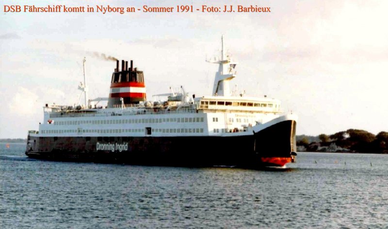 DSB -  Dronning Ingrid  kommt in Nyborg an. Der Bug ffnet sich langsam und hinter dem Bug sind mehr als 400 Meter Schienen, auf vier Gleisen verteilt.  In 1991, fr jede berfahrt Korsoer-Nyborg,waren zwei verschiedene Zge trajektiert : ein IR mit normalen Reisezugwagen, zwischen die zwei extremen links und rechts Schienen verteilt waren, und ein IC3 mit manchmal vier Einheiten von 3 Wagen. Der IC3, schneller (und mit Zuschlag) war am letzten Moment geplant und knnte sehr rasch sich auf die zwei Gleisen in der mitte rangieren. Spter ist der IR ausgefallen und nur ist der IC3 geblieben.
Nyborg - Juni 1991 - Foto : J.J. Barbieux
