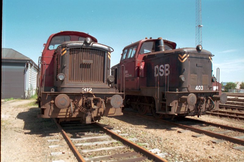 DSB MH 312 und 403 abgestellt im 04-1999 im Bahnhof Frederikshaven. Baujahr 1960, kW 323, km/h 60, Anzahl 119.
Photo und Scan G. Mannes.