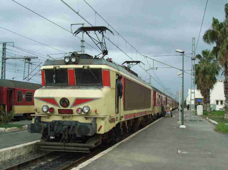 E-1351 hlt mit ihrem Schnellzug auf dem Weg von Casablanca nach Fes im Bahnhof Sidi-Kacem.
Die Lokreihe E-1350 wurde von Alsthom 1999 in Kooperation mit der marokkanischen Firma SCIF gebaut.
Sie sind fr 3000V-Gleichspannung ausgelegt und ansonsten der franzsischen Reihe BB-7200 hnlich.
24.01.2007 Sidi-Kacem