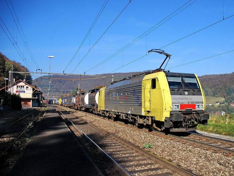 E 189 989 FM Dispolok. Sonne, blauer Himmel und eine leider schmutzige Lok vor einem Gterzug, der gerade den stillgelegten Bhf. Hornussen (Kanton Aargau Schweiz) passiert. 7.11.2006