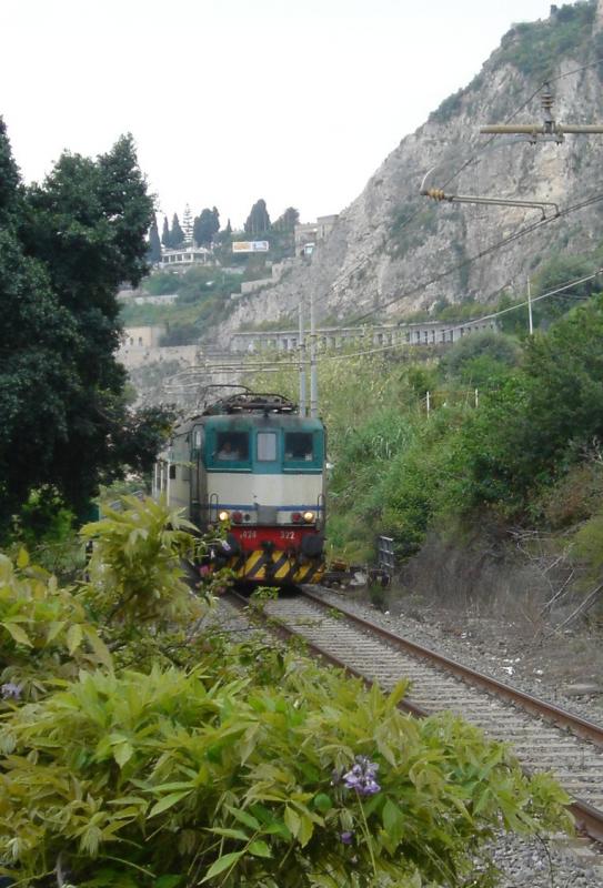 E 424 032 zeigt sich am 21.04.06 kurz mit ihrem Regionalzug auf ihrer Fahrt von Catania nach Messina am Fue der malerisch gelegenen Stadt Taormina um kurz darauf im Tunnel von Mazzaro zu verschwinden. 