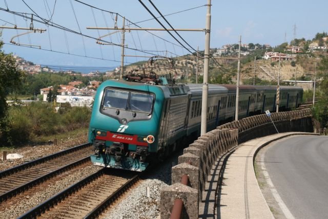 E 446.134 mit dem Regionalexpress 3457, Napoli Centrale - Paola bei der Fahrt durch die Ortschaft Destr. Im Hintergrund sieht man Agropoli am Golf von Salerno; 09.09.2007