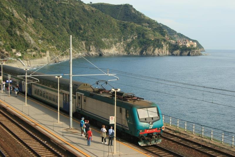E 464 300 steht mit der Kulisse der Riviera di Levante im Bahnhof von Corniglia; 25.04.2009