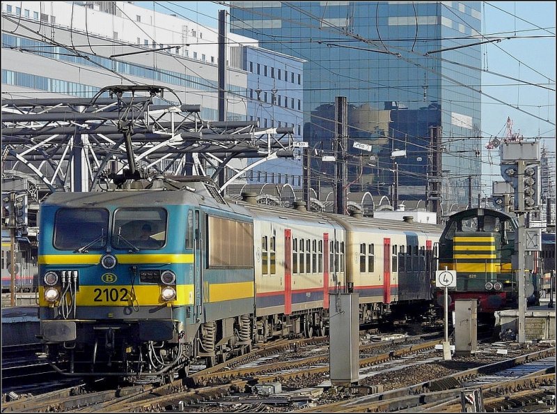 E-Lok 2102 verlsst mit ihrer M 4 Wagengarnitur den Bahnhof Bruxelles Midi in Richtung Quivrain. Rechts im Bild ist auch noch die abgestellte Rangierlok 8211 zu sehen. 14.02.09 (Jeanny)