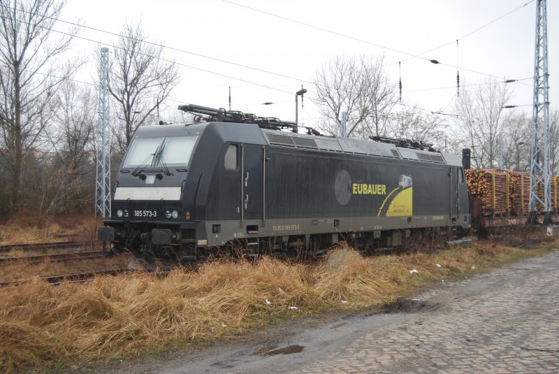 E-Lok der Baureihe 185 (185 573-3)von NEUBAUER mit Holzzug in Hoyerswerda.