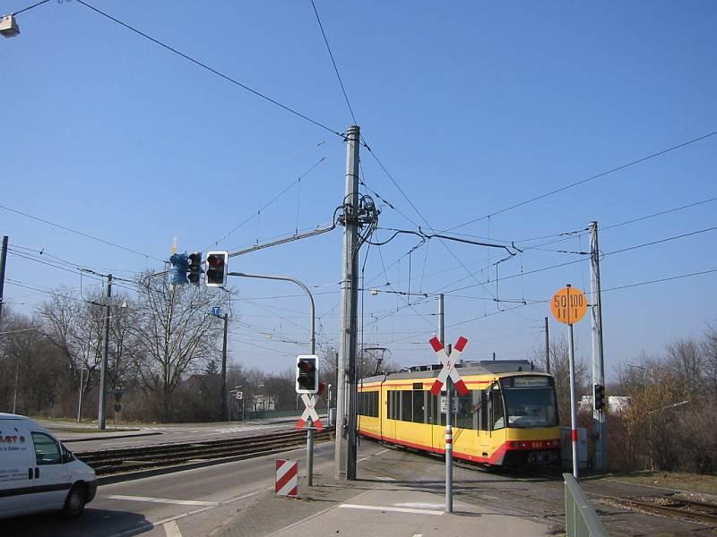 Eben noch fuhr Zweisystem-TW 861 die Rampe beim Bahnhof Karlsruhe-Durlach hoch, jetzt schwenkt er auf die Straenbahngleise der Durlacher Allee in Karlsruhe ein. Die Autos haben zu warten. Die Aufnahme stammt vom 20.03.2006 und entstand nur Sekunden nach dem vorherigen Bild.