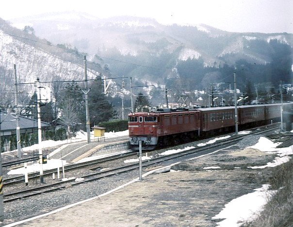 ED77, eine Steilrampenlok für die Strecke nach Aizu Wakamatsu. Drei vierachsige Drehgestelle, das mittlere nicht motorisiert; Wechselstromlok, wie alle Loks in der 70er-Reihe. Baujahre 1967 und 1970, total 15 Loks; alle bis 1993 ausgeschieden. Hier braust der Zug mit dem Fotografen drin die Steilrampe hoch, während die ED77 13 im Lokalbahnhof Nakayamajuku steht; 13.Februar 1985. 