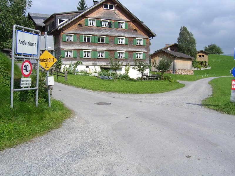 ehemalige Bregenerwaldbahn, km 27,9. Hier befand sich in der Andelsbucher Parzelle Bhel die Haltestelle  Bezegg . Es erinnert wirklich gar nichts mehr daran. Man hat das Gefhl, da sich hier einfach zwei Wege kreuzen. Der Weg in Fotorichtung ist allerdings die Trasse. Links vorne, bei diesem Bauernhaus befand sich frher eine Sitzbank sowie ein Schild mit der Aufschrift  Bezegg . All das ist schon lange verschwunden.
