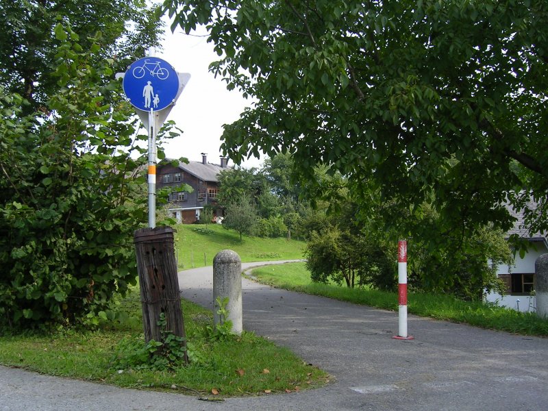 ehemalige Bregenzerwaldbahn, bei km 26,3. Diese Stelle befindet sich ca. 400m vor dem Bahnhof in Andelsbuch und zeigt, wie nett hier der Radweg auf der alten Bahntrasse angelegt wurde. Bitte achten sie vorne links auf die ehemalige Schwelle : in vielen Grten zwischen Egg und Andelsbuch wurden die alten Schwellen fr Zaunpfhle oder hnliches verwendet.