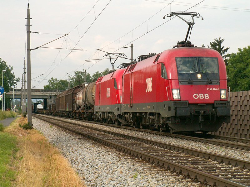 ein 1116 Tandem mit 1116 281 an der Spitze fhrt samt Gterzug gerade unter der Autobahnbrcke der Westautobahn kurz nach Ansfelden durch (6.6.2008)