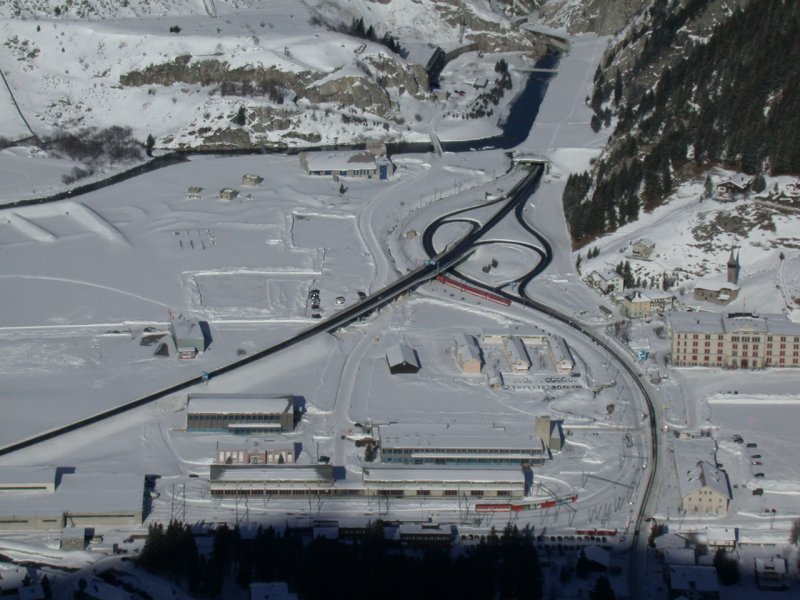 Ein Blick auf den Bahnhof Andermatt aus der Gemsstock Luftseilbahn. Soeben hat ein Pendelzug Andermatt Richtung Gschenen verlassen. Hinter der Galerie beginnt die Schllenenschlucht, die hinunter fhrt zum Portal des Gotthardtunnels.(14.01.2005)