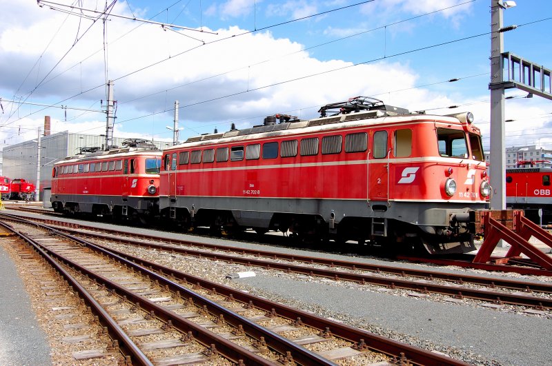 Ein  blutorangen-farbenes  Zwillingsprchen: Zwei  1142er  in den wrmenden Strahlen der Frhlingssonne, wobei 1142 702-8 diese eher gebrauchen kann nach ihrem Steinschlagschaden auf der Westbahn. Front- und Seitenscheibe bedrfen einer neuen Beglasung.
