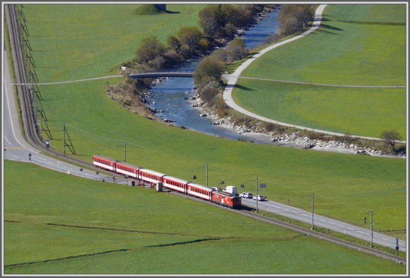 Ein Deh 4/4 II mit einem Regionalzug aus Brig passiert soeben den Bahnbergang ber die Gotthard Passstrasse in der weiten Ebene zwischen Hospenthal und Andermatt. Auch Anfangs Oktober sind hier die Wiesen noch erstaunlich grn. (08.10.2007)