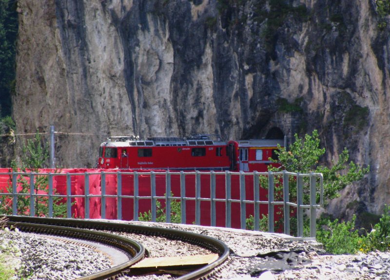 Ein etwas anderer Blickwinkel auf den verhllten Landwasserviadukt, der auch die verschlungene Streckenfhrung der Albulabahn erahnen lsst. Ge 4/4 II 619  Samedan  verlsst mit ihrem Albulaschnellzug soeben mit sehr kleiner Geschwindigkeit den kurzen Landwassertunnel. (19.Juli 2009)