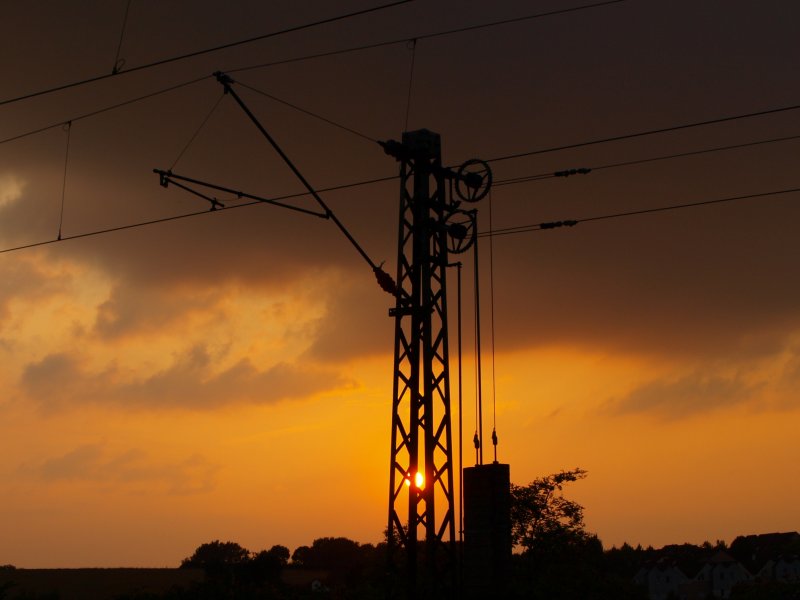 Ein Fahrleitungsmast im Licht des Sonnenuntergangs am Gemmenicher Weg in Aachen.