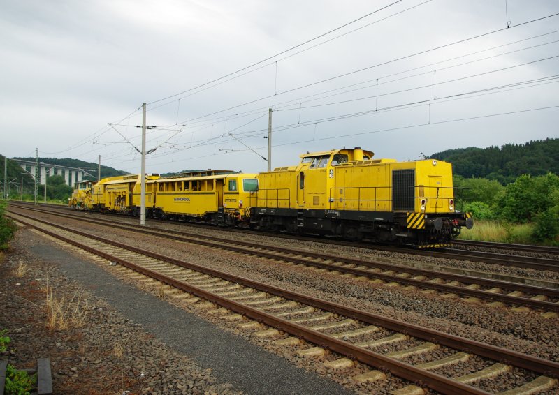 Ein gelber Farbklecks vor grauer Tristesse: V150.04 mit Bauzug zwischen Eisenach und Herleshausen. 24.07.2009.