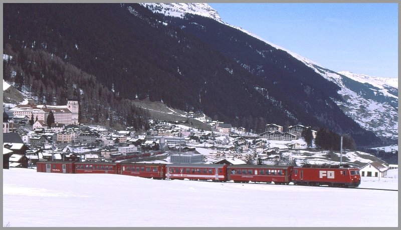 Ein gemischter RhB/FO Zug auf dem Weg zum Oberalppass. Im Hintergrund ist das Kloster Disentis und der Bahnhof zu sehen. (Archiv 03/90)