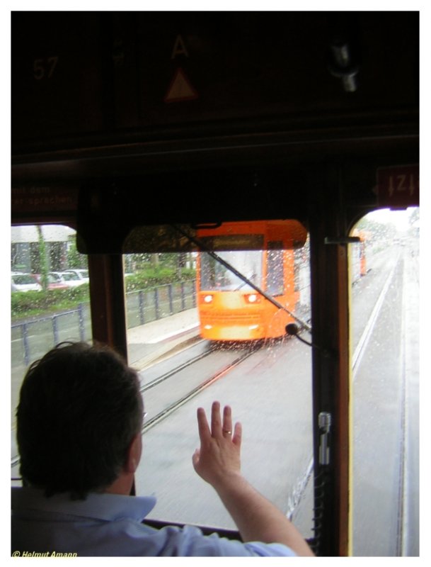 Ein Gru� unter Kollegen: Der Fahrer des historischen Triebwagens 57 der Darmst�dter Stra�enbahn vom Typ ST3 gr��t am 21.05.2006 den Fahrer des entgegenkommenden Zuges der Linie 9 mit Triebwagen 9871 und Beiwagen 9452, der die Fahrg�ste ebenso trocken durch den gerade herunterkommenden Regenschauer bef�rderte wie es der Kollege mit uns tat.