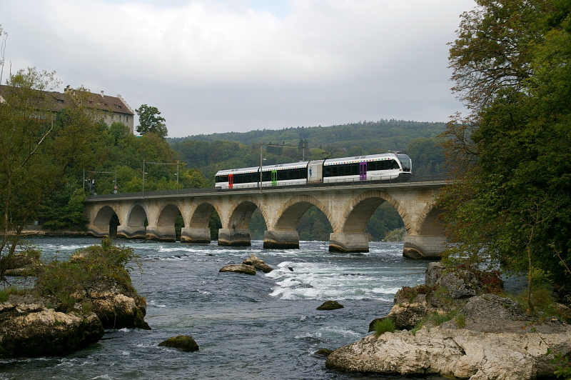 Ein GTW 2/8 am 25. September 2009 auf der Fahrt von Winterthur nach Schaffhausen. Der Triebzug hat eben den Haltepunkt Schloss Laufen verlassen und berquert nun den Rhein. Die beiden Baukrne, welche zum Aufnahmezeitpunkt das Schloss verschandelten, habe ich wegretuschiert.
