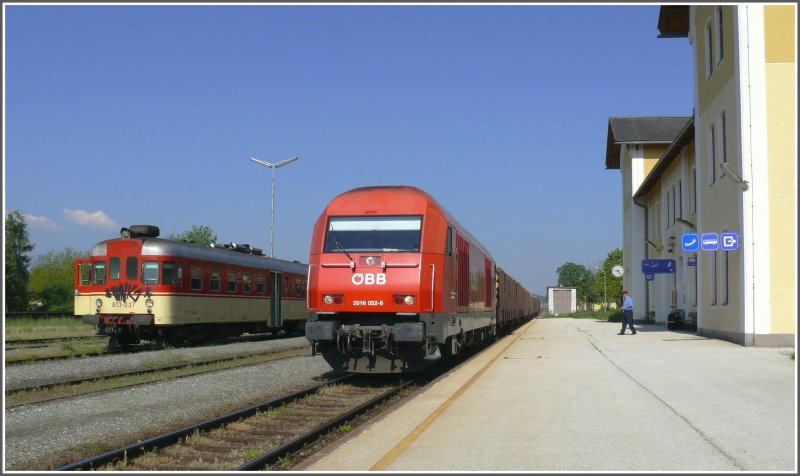 Ein Holzzug mit der 2016 052-9 fhrt durch den Bahnhof Bleiburg Richtung Wolfsberg und berholt einen der zwei tglichen Personenzge der SZ nach Maribor, bestehend aus Triebwagen 813-037 und Steuerwagen 814-037. (14.05.2008)
