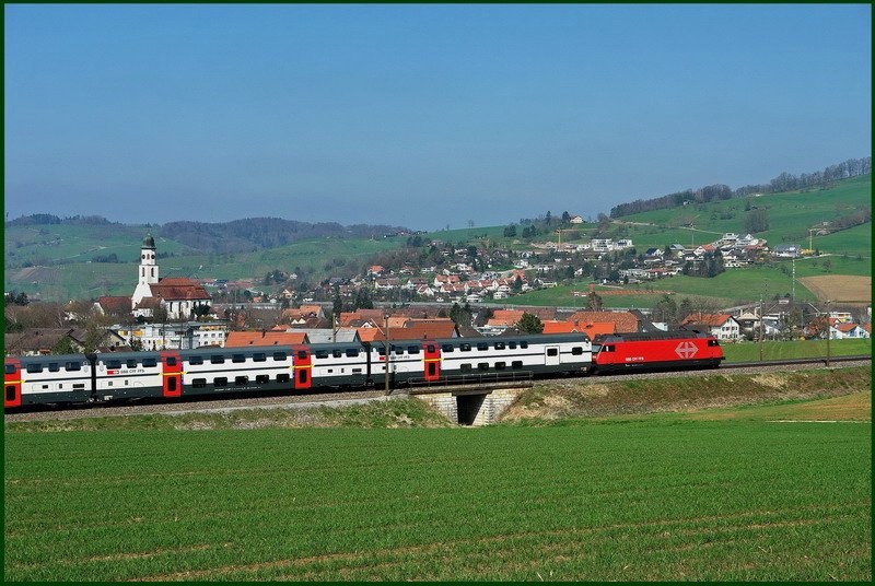 Ein InterRegio mit Doppelstock-Wagen ist im Fricktal unterwegs  nach Zrich. Links im Bild ist die mchtige Barockkirche von Frick (Aargau) aus dem Jahre 1716 gut zu erkennen. 1.4.2007