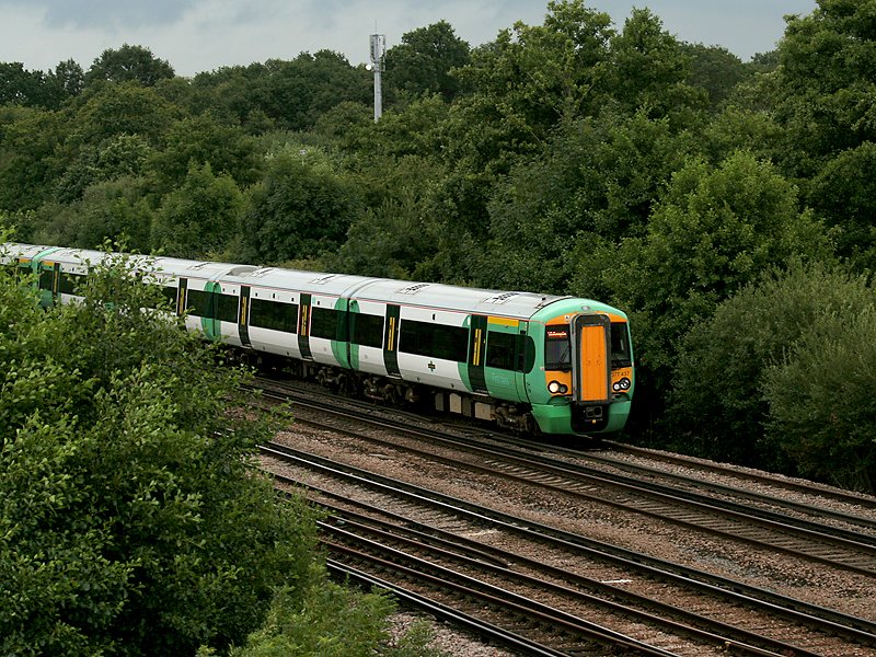Ein moderner Triebzug  Class 377  der Electrostar-Familie hat den Flughafenbahnhof von London Gatwick verlassen und beschleunigt Richtung Sden. (17.07.2008)