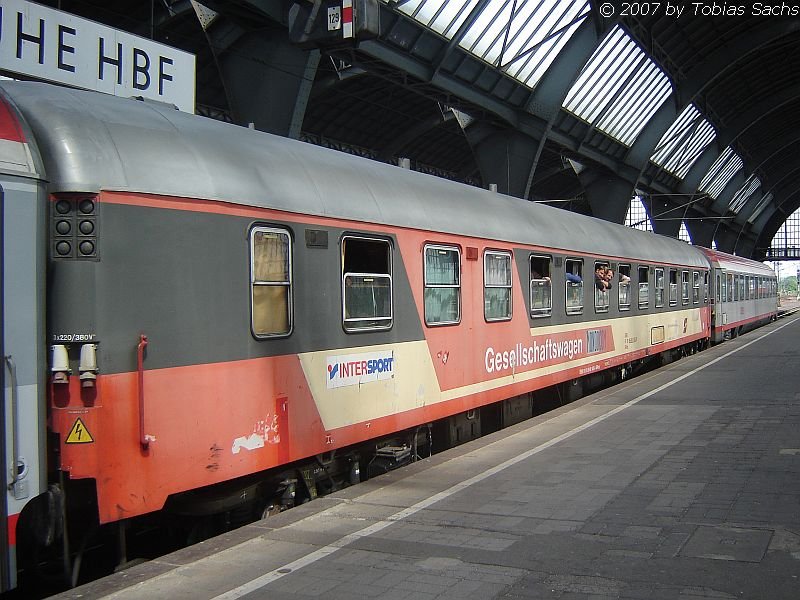 Ein sterreichischer altlackierter Gesellschaftswagen auf Gleis 9 zwischen 2.-Klasse-Abteilwagen in Karlsruhe. 