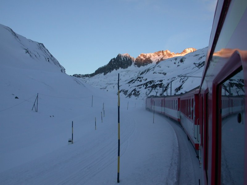 Ein Pendelzug der MGB unterwegs von Disentis nach Andermatt kurz vor der Oberalppasshhe 2033m/.M an einem kalten Wintermorgen des 14.01.2005. Die Passstrasse neben der Bahnlinie hat Wintersperre und wird nur von Skifahrern bentzt.