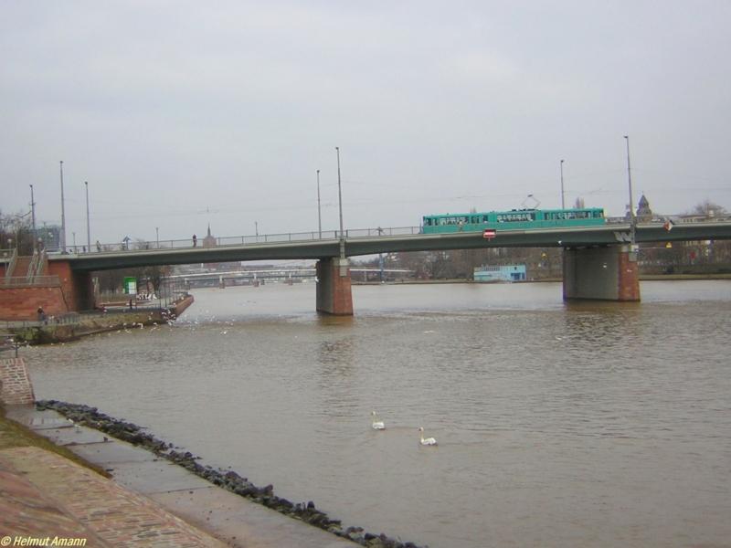 Ein Pt-Triebwagen der ersten Bauserie in neuer Farbgebung am 26.02.2006 auf der Linie 12 beim berqueren der Friedensbrcke in Fahrtrichtung Schwanheim. Halblinks im Hintergrund ist die Spitze des Frankfurter Doms zu sehen.