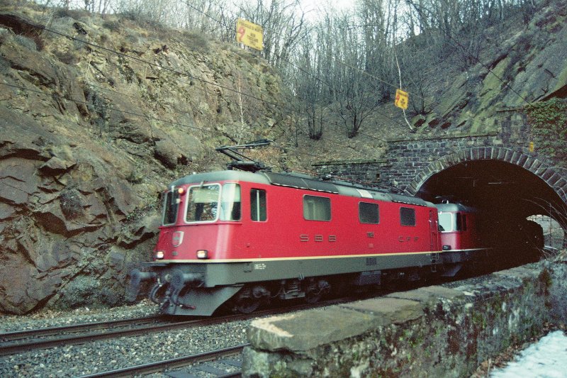 Ein Re 10/10-Packet kommt aus einem Tunnel zwischen Mezzovico und Taverne-Torricella im Feb. 2005.