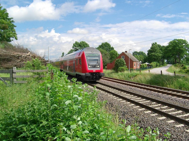 Ein RE von Lbeck Hbf nach Hamburg Hbf rauscht im Sommer 07 bei Dehlingsdorf an meiner Kamera vorbei.