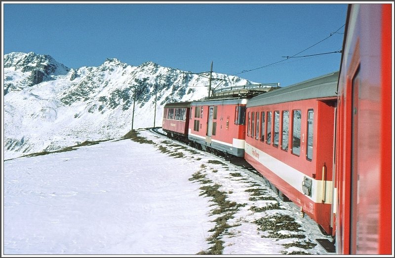 Ein Regionalzug mit BDeh 4/4 berfhrt einen Speisewagen der RhB und befindet sich auf Talfahrt unterhalb Ntschen. (Archiv 12/82)