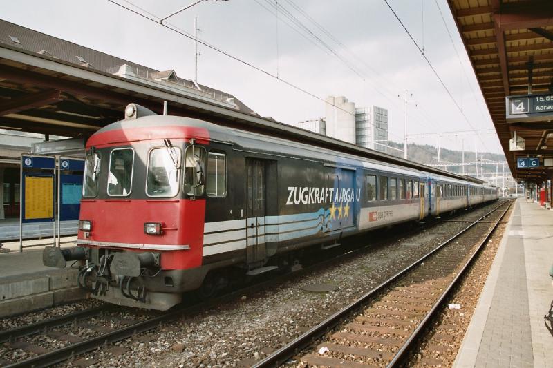 Ein Regionalzug mit fnf Wagons, inklusive Steuerwagen, haben alle die Aufschrift  ZUGKRAFT AARGAU , am 07.03.04 in Brugg HB