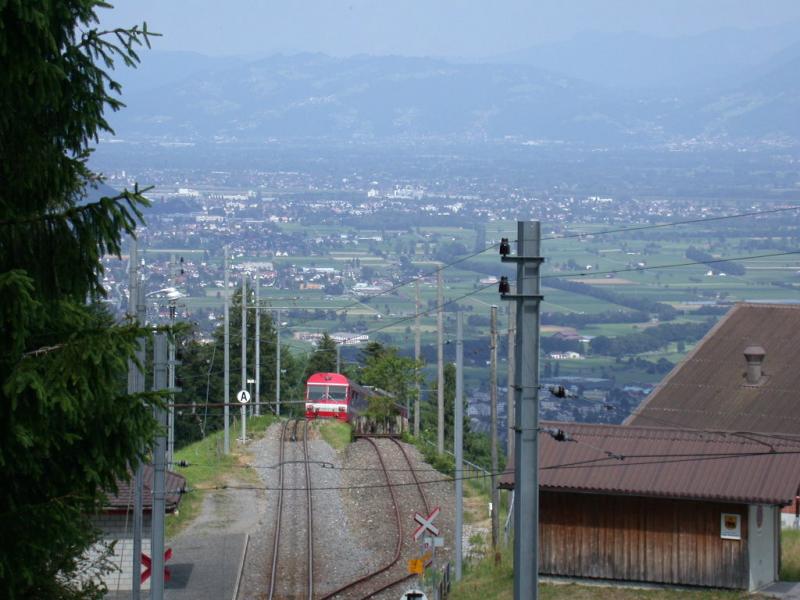 Ein Regionalzug mit Trieb- und Steuerwagen der AB trifft an der Haltestelle Kreuzstrasse ein. Der Zahnstangenabschnitt beginnt von neuem unmittelbar hinter der Weiche und der Strasse, die dort gekreuzt wird. (01.07.2001) Im Hintergrund ist das Rheintal zu erkennen mit Altsttten und den Bergen jenseits der Grenze in Vorarlberg.