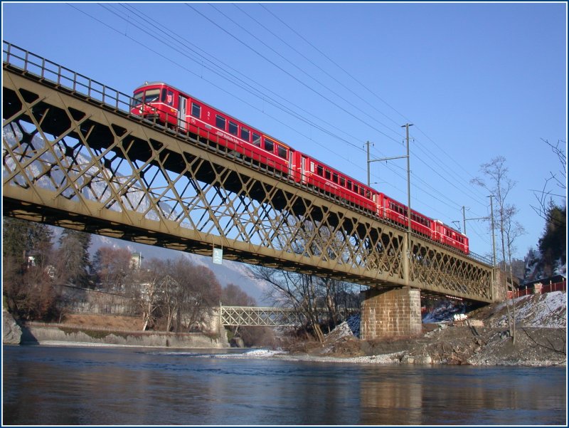 Ein Regionalzug nach Rhzns berquert bei Reichenau-Tamins den Hinterrhein. Links befindet sich der Zusammenfluss von Vorder- und Hinterrhein, im Hintergrund ist die Strassenbrcke ber den Rhein nach Tamins zu sehen. (31.01.2007)