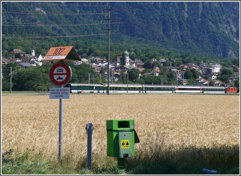 Ein Rheintalexpress auf dem Weg nach Chur bei Zizers. Die orange Tafel 102 markiert den unterirdischen Verlauf einer Hochdruckgasleitung und der grne Behlter sollte den Hinterlassenschaften der Hubde dienen. (09.07.2008)