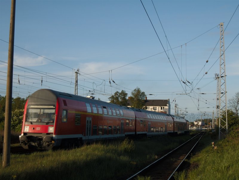 Ein S-Bahnzug fhrt in den Bf Warnemnde-Werft ein. Im Hintergrund das Haus ( ber  dem zweiten Wagen) ist das Empfangsgebude des alten Warnemnder Bf's bzw. da wo noch vor der Elektrifizierung die Zge hindurch fuhren.
05.mai 2009