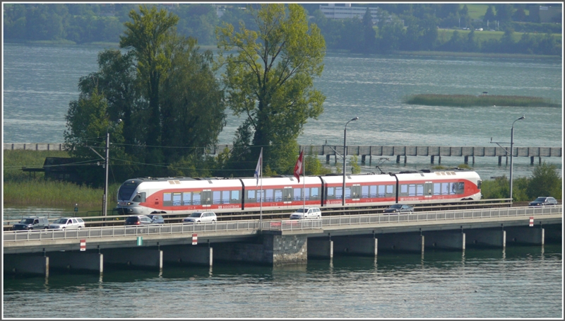 Ein Stadler Flirt 526 bnerquert den Zrichsee bei Rapperswil. (18.08.2009)