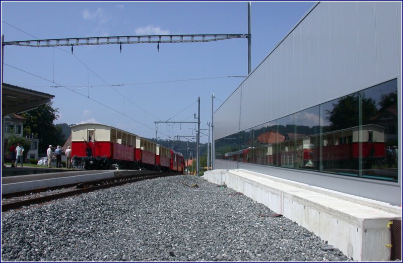 Ein Zug mit Fahrradwagen und drei offenen Sommerwagen erreicht Heiden und spiegelt sich in der Fensterfront des neuen Depots. (13.08.2007)