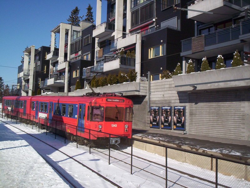 Ein Zug der T-Bahn Oslo durchfhrt die Haltestelle Holmenkollen. Von hier ist es nicht weit zur Skisprungschanze. Dieser Zug macht eine Leerfahrt wie am Zugzielanzeiger zu erkennen ist. Ikke i traffik = nicht im Verkehr.Fotografiert am 15.03.2005
